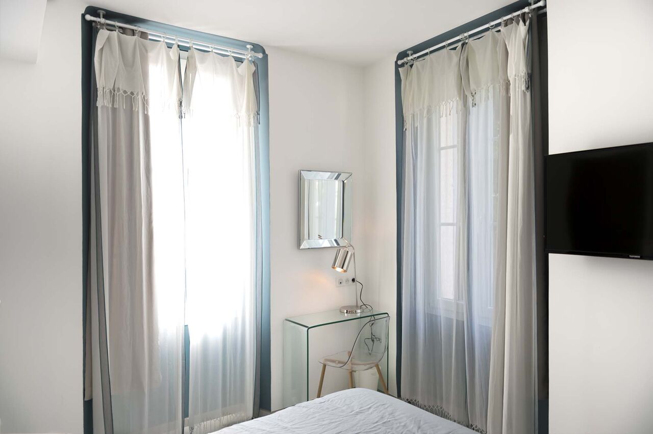 Deux rideaux et miroir dans chambre d'appartement à Cannes - Villa Marceau